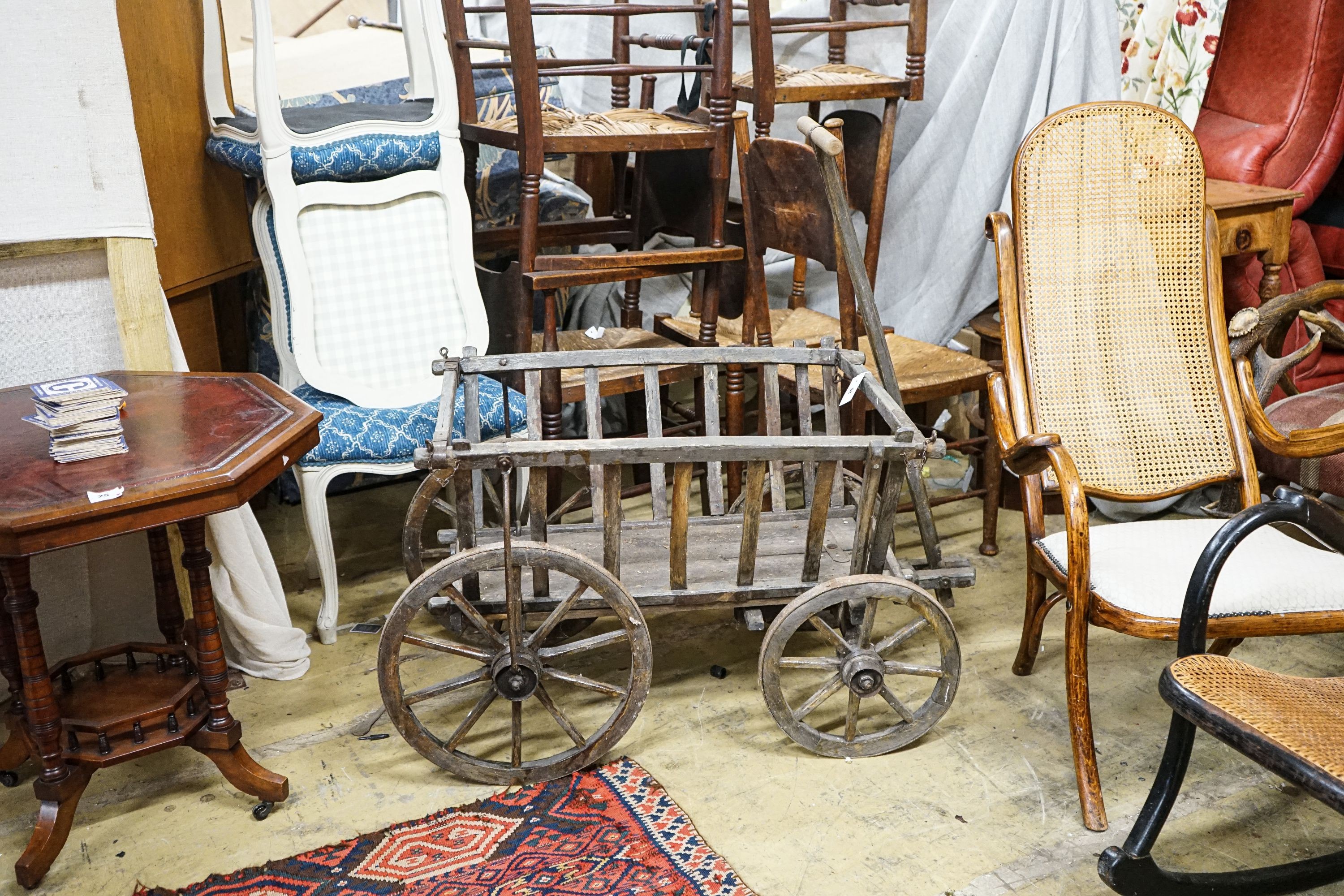 A Victorian oak and beech framed child's cart, with iron bound spoked wheels, length 104cm, depth 58cm, height 60cm